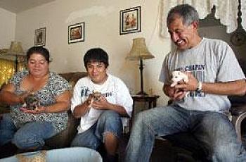 Calixto Orantes, right, his son Julio, 17, center, and wife Edel, left, play with their new puppies at their home.
