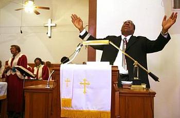 The Rev. Jeffrey M. Parker prays during a service at Community Reformed Church in the Sobrante Park neighborhood.
