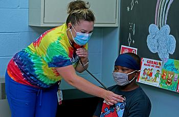 Starms Discovery Learning Center school nurse Ashley Capodarco exams student Major Wilson, 9, in her office. Asthma is the most 