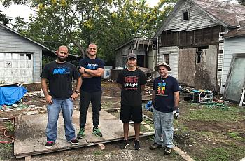 Amilcar Heredia, Eduardo Assef, Robert Santos and Isaac Fonseca stand outside Reynaldo Garza’s home after cleaning up debris in 