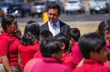 Tony Alcalá, director de la Galveston Elementary School, escucha a un grupo de alumnos de cuarto grado durante el recreo en Chan