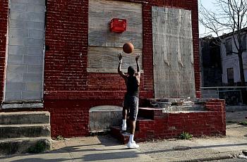 A boy shoots a basketball into a makeshift basket made from a milk crate and attached to a vacant row house in Baltimore, April 8, 2013. Patrick Semansky/AP Photo
