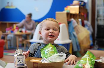 Two-year-old Jesse Bryson enjoys a bag of Sun Chips during the Seamless Summer Food program at the Family Resource Center of the