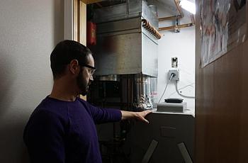 Aaron Cooke demonstrates a heat-recovery ventilator at his house in the sustainable house at the Cold Climate Housing Research C