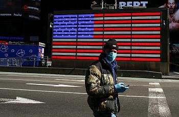 A man wears a face mask as he check his phone in Times Square in New York City. 