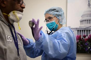 A nurse practitioner examines a patient.