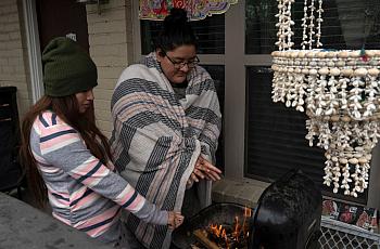  Karla Perez and Esperanza Gonzalez warm up by a barbecue grill during power outage caused by the February winter storm.