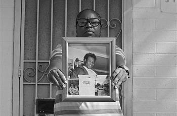 Sherika Simms holds the last photo taken of her brother, Maurio Proctor, outside one of their childhood apartments in Jordan Downs. Sahra Sulaiman/LA Streetsblog