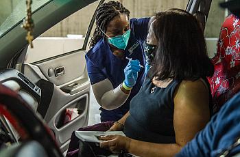  Amaka Iheaka gives a shot to Yolanda Penaflor at a COVID-19 vaccination clinic at the Long Beach Convention Center on April 1, 