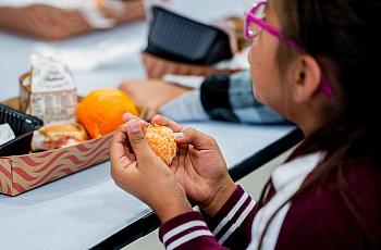 A student eats an orange during lunch at Don Stowell Elementary School in Merced, Calif., on Tuesday, May 14, 2019. 