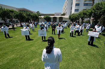Health care workers participate in a “White Coats for Black Lives” event in solidarity with George Floyd and other black America