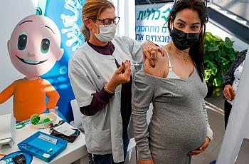 A pregnant woman is vaccinated against COVID-19. 