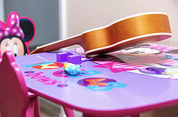 Nadia's Minnie mouse play table, with a small guitar on it.