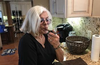 Linda Tisbo, a member of the Laguna Woods Medical Cannabis Collective, cleans out her pipe on April 11, 2018. 