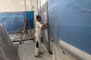 A worker performs lead paint and plaster stabilization at Clara Barton Elementary School.