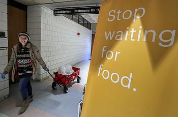 Henny Ransdell pulls a wagon carrying Einstein Bros. Bagels in the Bingham Humanities Building on UofL's campus. The bagels, don