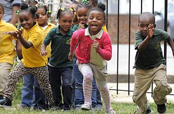 Students at Little Flowers Child Development Center laugh and play during a morning on the playground. Some of the children who attend the Baltimore school are exposed to violence in their neighborhood - an exposure scientists increasingly realize can cause health impacts. (Lloyd Fox, Baltimore Sun)