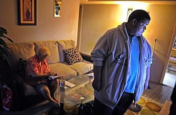 Deonta Ridley watches TV while his grandmother, Nellie Diaz, fishes around in her purse for money so he can go to the store to get them a snack. Diaz has diabetes, and Deonta learned last year that he has elevated cholesterol and is at risk for developing diabetes. / Larry McCormack / The Tennessean