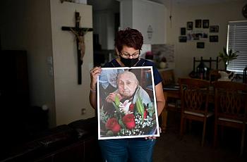 Marisela Munoz holds a photo of her aunt, Evangelina C. Martinez, who raised her since birth, at her home in Canyon Country, Fri