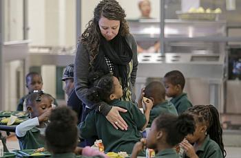 Lawrence D. Crocker College Prep counselor Rochelle Gauthier gets a hug from a student during lunch at the school in New Orleans