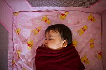 A 10-month-old girl takes a nap in the child development center.