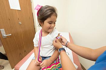 A health care provider gives a child a flu vaccine.