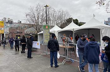 As people wait to take the Binax rapid test at 24th St. Mission BART Station Plaza, they fill out online surveys that question t