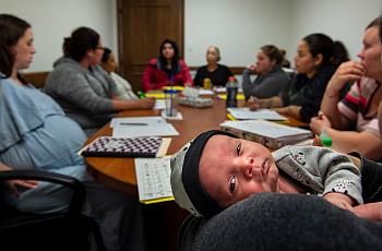 One-month-old baby Alexander is comfortable in his mom, Elia R’s arms during a group therapy session for women and mothers deali