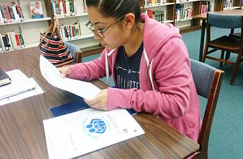 DACA recipient Stephanie Martinez reviews the Medi-Cal documents she received by mail. (EGP photo by Jacqueline Garcia)