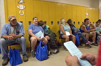 People wait for vision care at Lee County High School during a remote area medical clinic last year. 