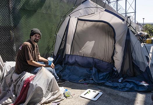 Person sitting in front of a tent