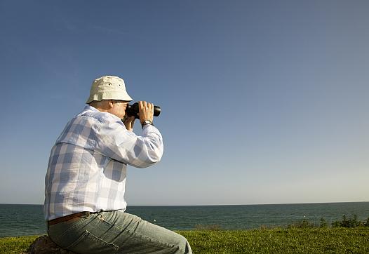 Man looking through a binoculars 