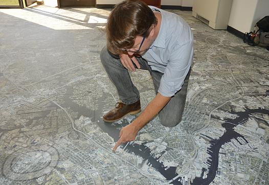 Person pointing at a map on the floor