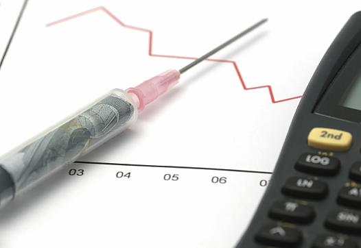 Syringe on a chart beside a calculator