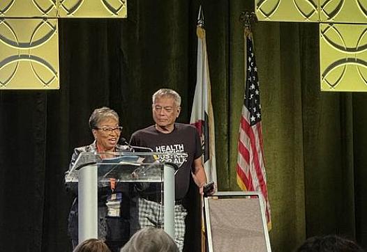 Two people at podium on stage