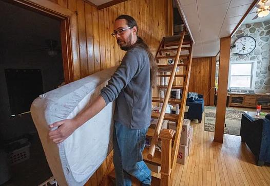 Erick Vertein shown moving a mattress.