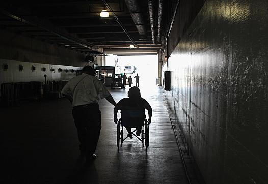 patient in a wheelchair being helped by a paramedic