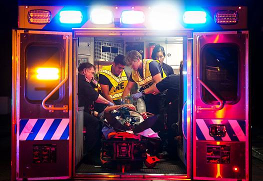 Image of paramedics and firefighters in firetruck saving victim