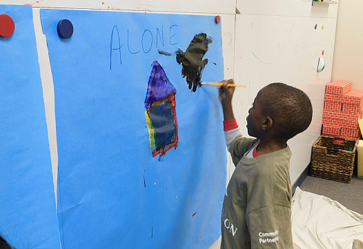 Child painting on blue paper