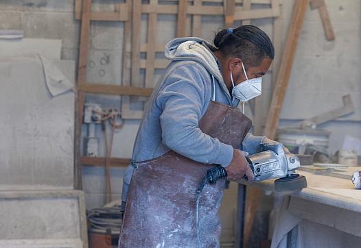 Person with a mask on using a power tool
