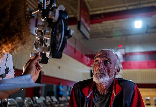 A man takes a vision test for a new pair of glasses at a remote-area mobile dental and medical clinic.