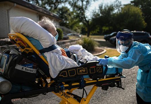 An elderly patient is transported on a gurney.