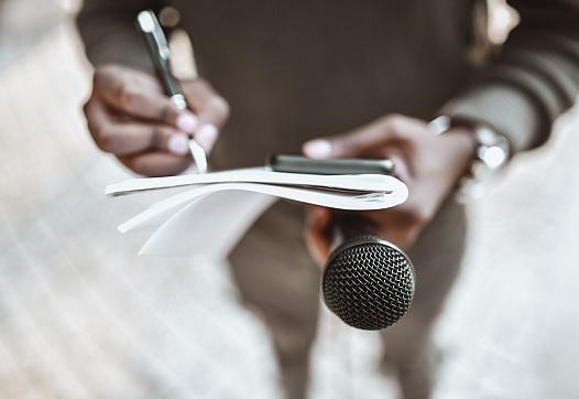 Journalist with notebook and microphone.