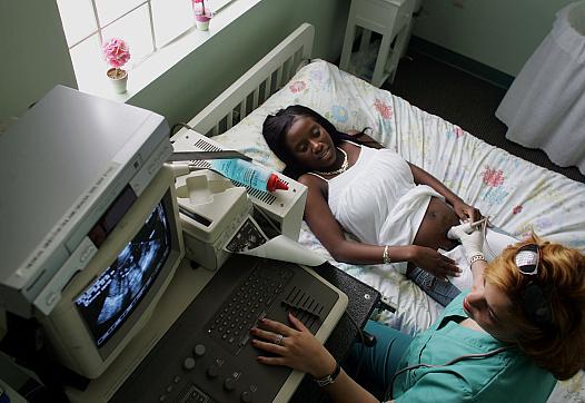 A pregnant mother undergoes a sonogram at a medical facility.