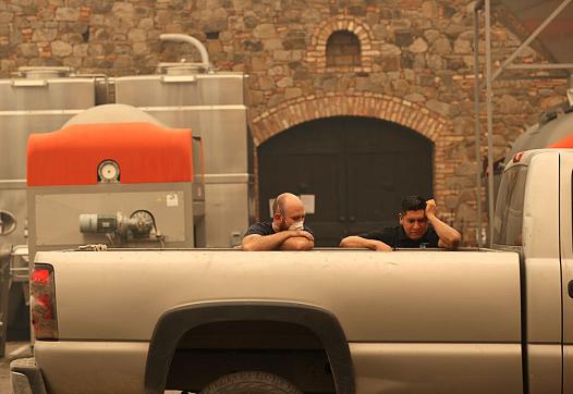 Image of two people sitting in the back of pickup truck tensed and one is wearing mask