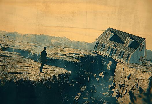 Person standing on the edge of a cliff with a house in the background