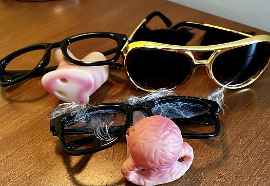 3 sunglasses and pink nose props on the table
