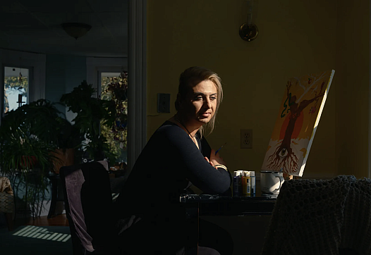 Person sitting in front of a painting