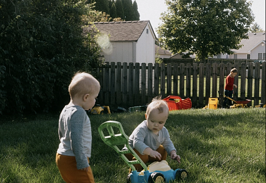 2 children playing in grass