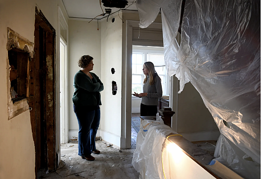 People in a house covered in tarp